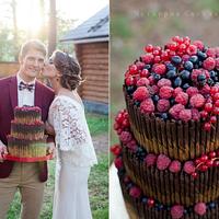 Wedding cake with berries and chocolate pencils.